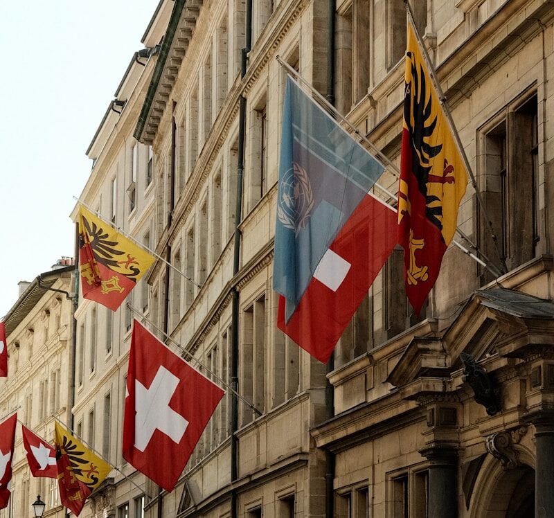 A row of flags on a street next to a building